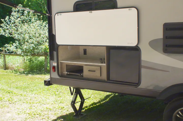 An RV rental showing its open outdoor kitchen: countertop, power outlet, pull-out rack, drawer, and mini-fridge.. Apex Nano 245 BHS 2020
