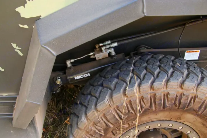 Close-up of a rugged RV rental's off-road tire and Maxim hydraulic suspension, ideal for tough terrain.. Xplorer X22 2022