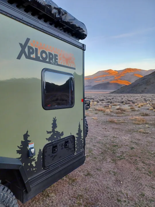 Rugged olive-green XPLORE RV camper parked in a high desert setting, ready for your next adventure or RV rental.. Xplorer X22 2022