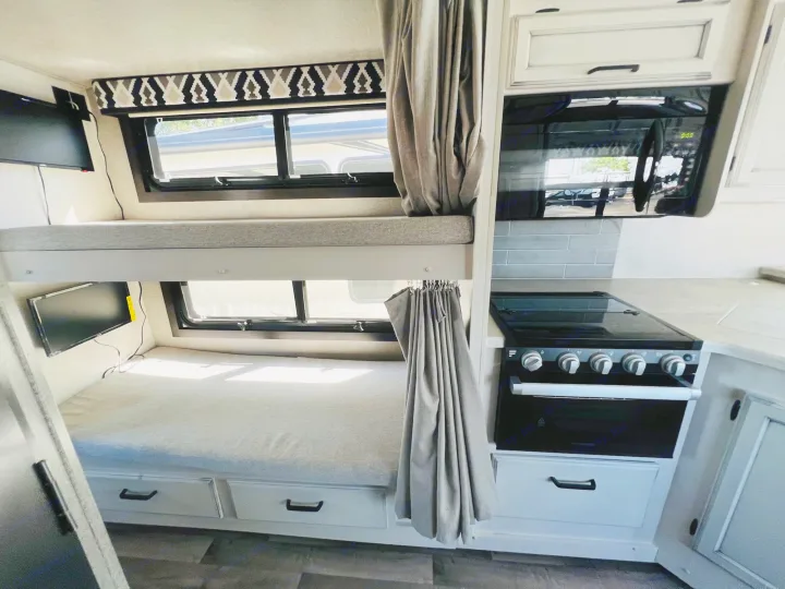 Modern RV rental bunkhouse: comfortable beds with TVs, plus a fully equipped kitchen with stove, oven, and microwave.. Jayco Alante 2021