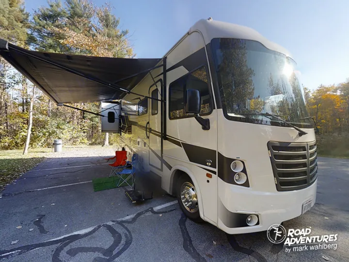 Experience outdoor freedom with an RV rental! This motorhome is parked at a sunny campsite with its awning extended.. Forest River Fr3 2021