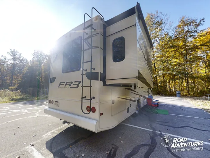 A spacious FR3 Forest River motorhome RV rental parked at a sunny autumn campsite, chairs set for relaxation. A perfect road adventure.. Forest River Fr3 2021