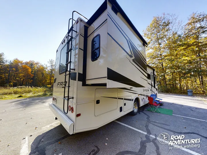 Enjoying the autumn colors with a spacious RV rental. This motorhome is parked with chairs set up, ready for outdoor adventure.. Forest River Fr3 2021