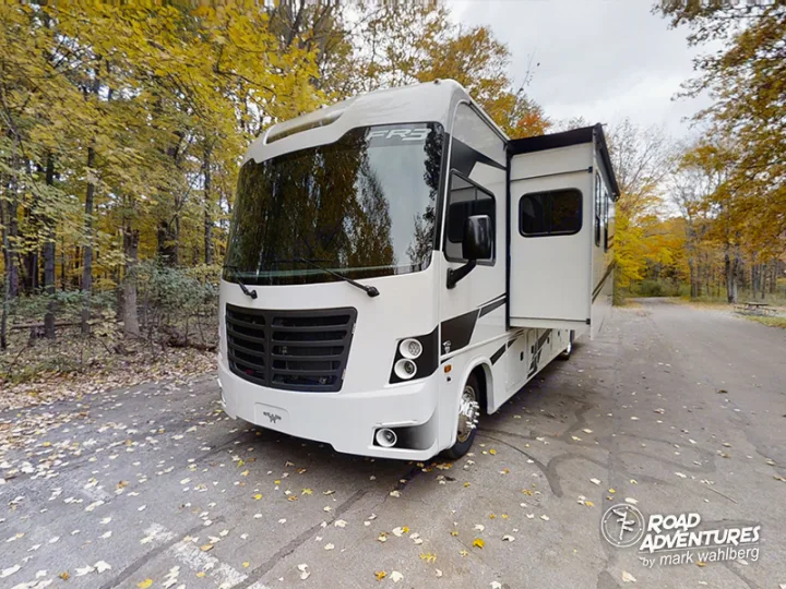 Spacious white RV rental amidst vibrant autumn foliage. Perfect for a relaxing fall road trip and camping adventure.. Forest River Fr3 2021