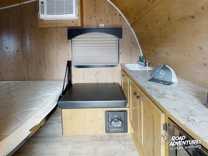 Step inside this RV rental! Features include a comfy bed, bench seating, compact kitchen sink, and AC for your travels.. Sunset Park Sunray 2021