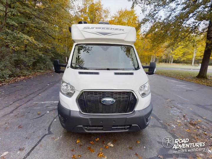 Front view of a white Ford Sunseeker RV rental parked on an autumn road, ready for your next adventure.. Forest River Sunseeker 2022