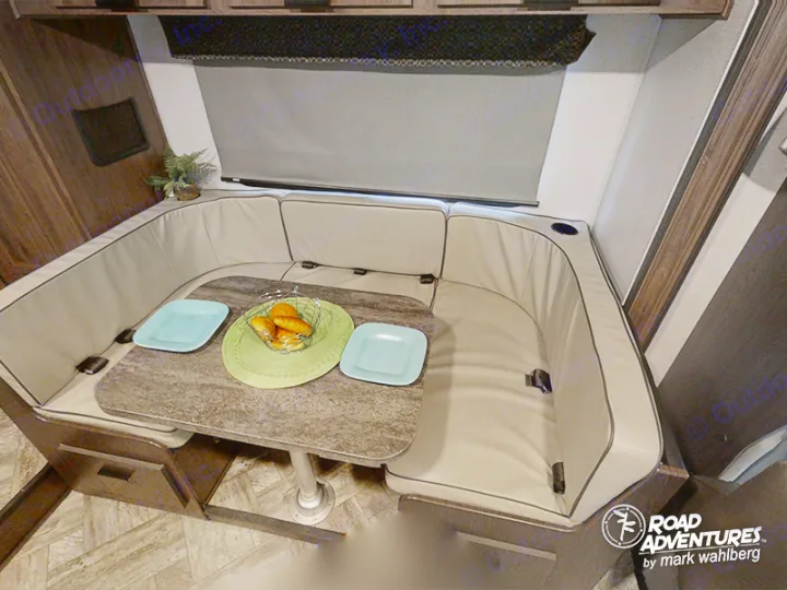 Spacious RV rental dinette featuring comfortable U-shaped seating, a table, and two place settings for relaxed travel dining.. Forest River Sunseeker 2022