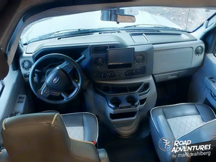 View of an RV rental's spacious cockpit, with a Ford steering wheel, dashboard, and comfy front seats. Ready for adventure!. Forest River Sunseeker 2022