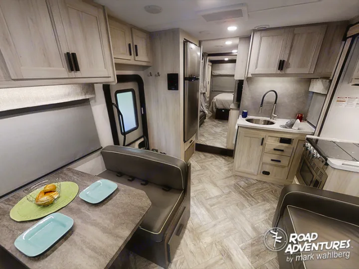 Spacious, modern RV rental interior featuring a bright dinette, well-equipped kitchen, and cozy bedroom.. Forest River Sunseeker 2022