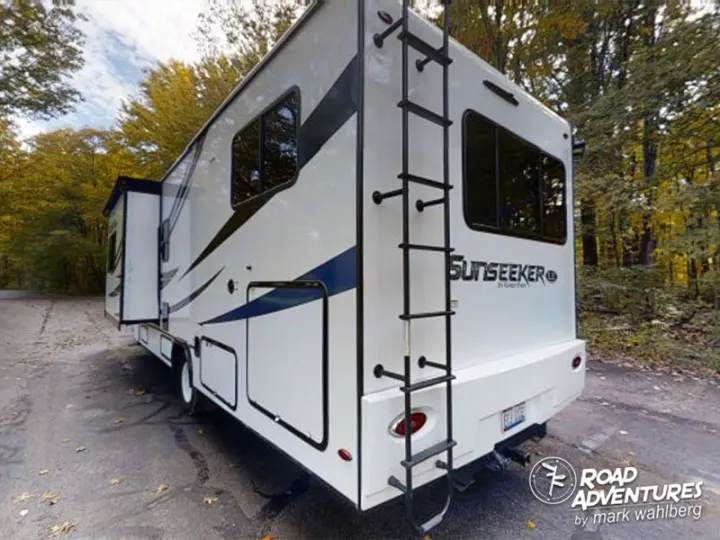 This white RV rental, a Sunseeker motorhome, is parked in a scenic autumn forest, ready for your road adventure.. Forest River Sunseeker 2022