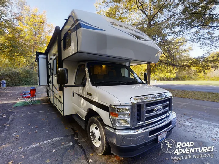 A white Class C RV rental is parked at a fall campsite with chairs out. Ready for your next road adventure!. Forest River Sunseeker 2022