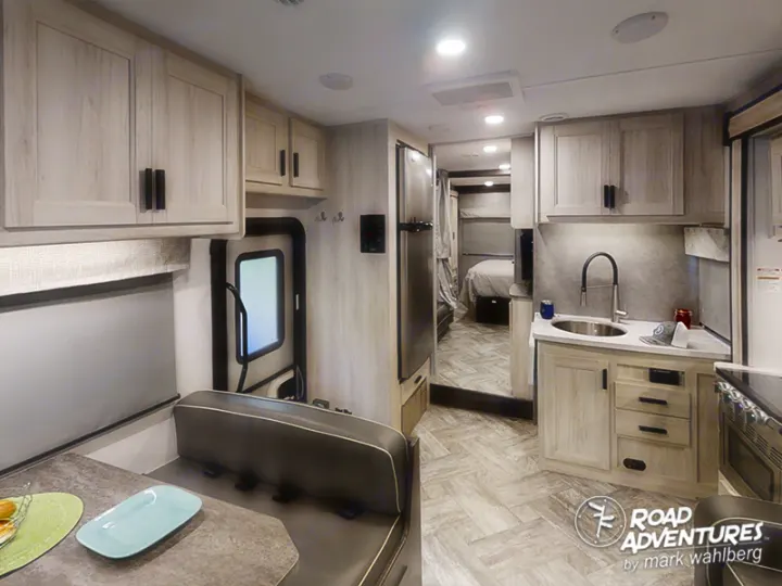 Experience comfort on the go! This RV rental features a bright, modern interior with a well-equipped kitchen, cozy dining area, and spacious bedroom beyond, ideal for your next road adventure.. Forest River Sunseeker 2022