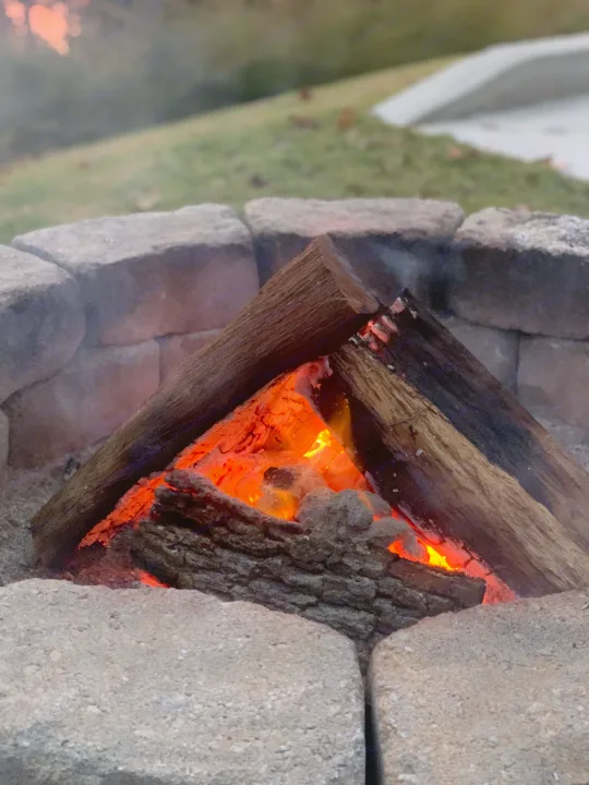 Cozy campfire glowing in a stone pit, an inviting scene for a relaxing evening on your next RV rental adventure.. Keystone RV Springdale 2021