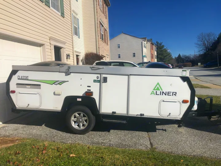 This A-liner Classic pop-up camper, ideal for an rv rental, parked on a sunny driveway.. A Liner A Liner Popup Trailer 2014