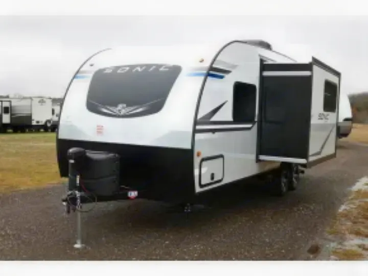 A white and black Sonic travel trailer RV rental with its slide-out extended, ready for spacious travel and camping.. Sonic Sonic Trailer 2025