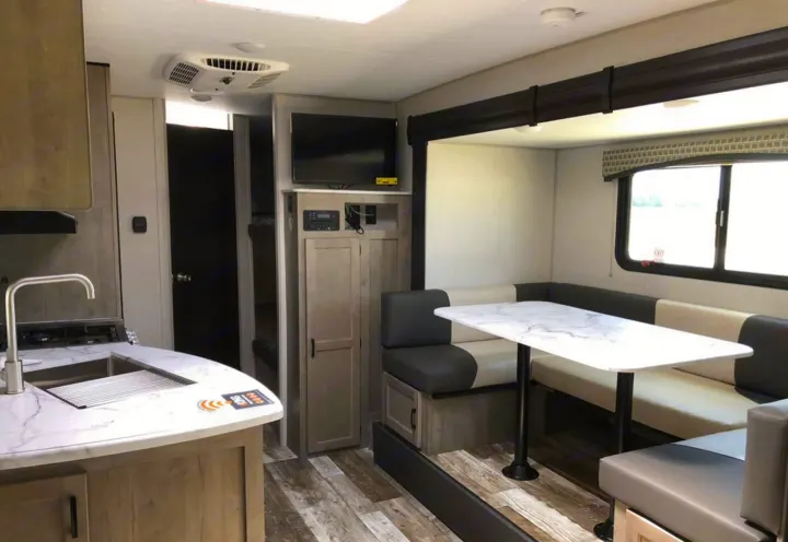 An RV rental's spacious interior, featuring a bright kitchen, comfortable dinette, and an entertainment system.. Sonic Sonic Trailer 2025
