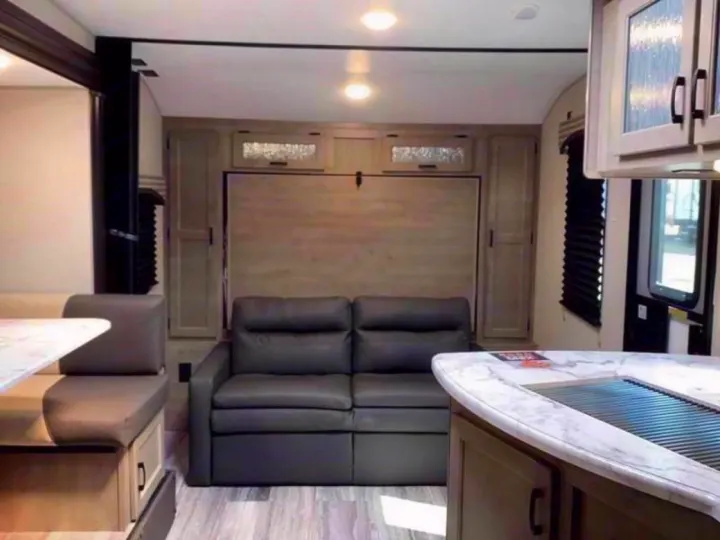 RV rental interior with sofa/murphy bed, dinette, and kitchen counter, showcasing a compact living space.. Sonic Sonic Trailer 2025