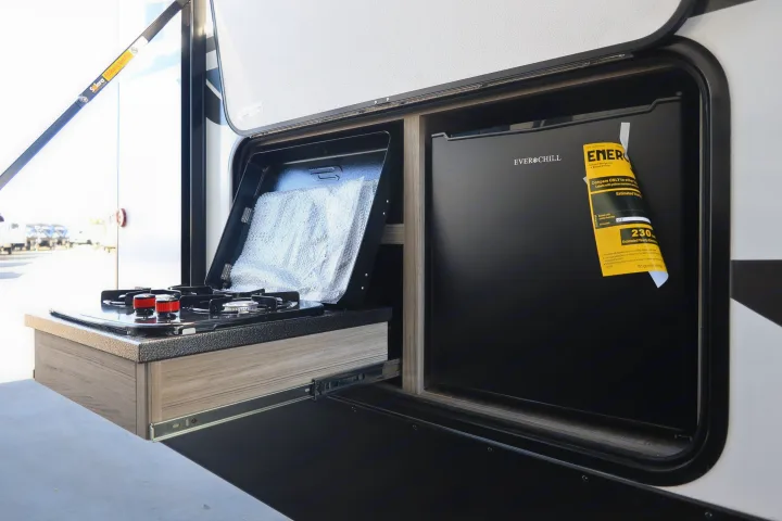 This RV rental features a pull-out outdoor kitchen with a gas stove and an Ever Chill mini-fridge, ideal for camping.. KeyStone Passport SL 221BH 2022