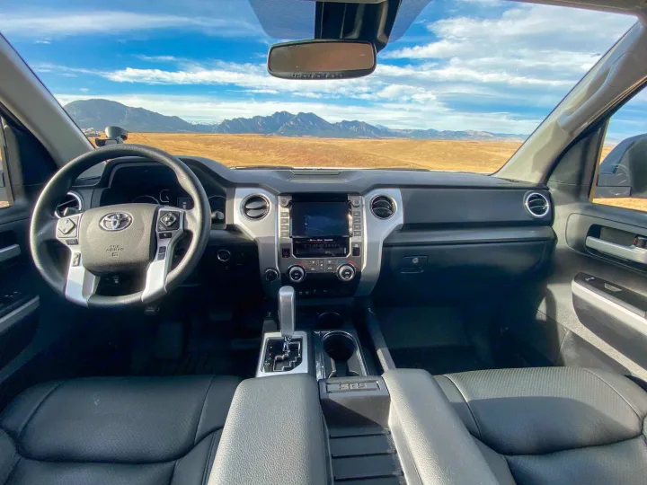 A vehicle's interior frames a stunning landscape: mountains, golden plains, blue sky. A great start to an RV rental trip.. Toyota Tundra 2021