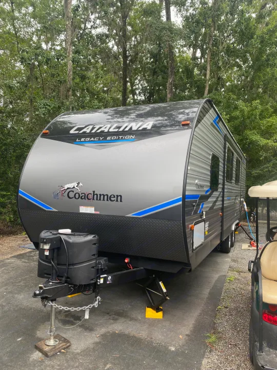 Grey Coachmen Catalina travel trailer at an RV rental campsite, hooked up & ready for your outdoor adventure.. Forest River Coachmen Catalina Legacy 2021