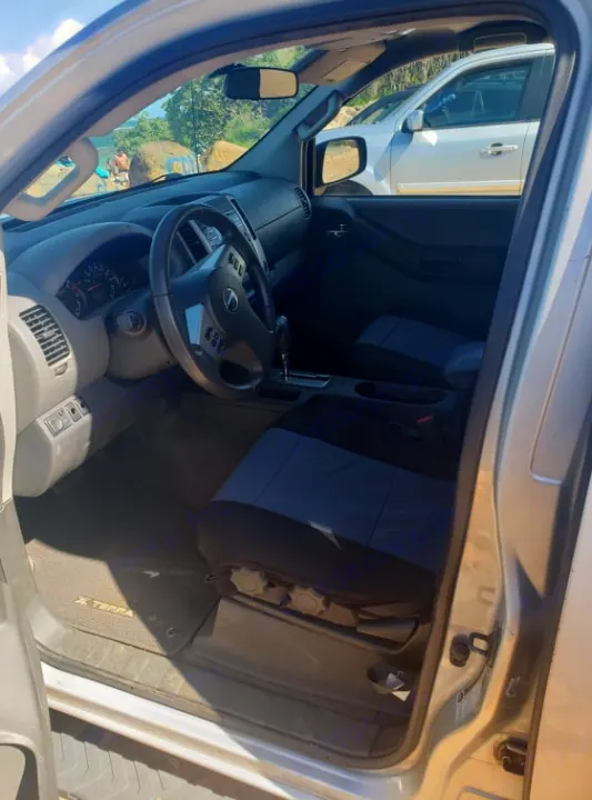 Interior of an Xterra SUV, showing the dashboard, steering wheel, and front seats. Perfect for rugged travel or an RV rental adventure.. NISSAN XTERRA 2014