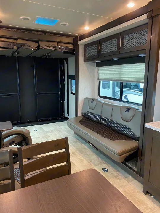 RV rental interior: Spacious toy hauler with convertible sofa bed, bunks, and dining area, ready for adventure.. Grand Design Momentum 2021