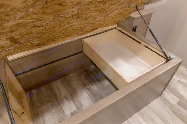 Efficient RV rental storage features under-bed access, a pull-out drawer, and a deep compartment for organized living.. Grand Design Imagine 2021