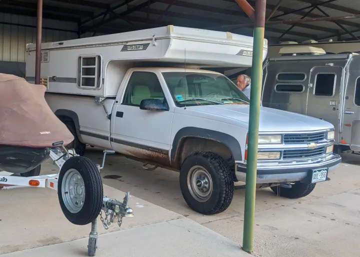RV rental: A white pickup with a Lite-Craft truck camper & an Airstream Bambi trailer are stored under cover.. Chevrolet Open Road 1998
