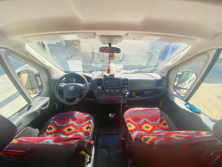 Inside a Ram ProMaster RV rental cab with vibrant patterned seats, dashboard, and front view for your road trip.. Dodge Ram Promaster 2500 2017