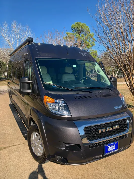 This dark grey Winnebago Ram ProMaster camper van is ready for your next rv rental. Parked outdoors on a sunny day.. Winnebago Travato 2022