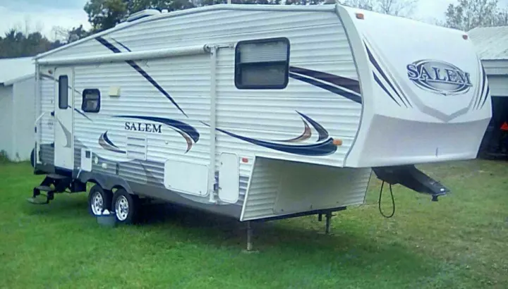 A white Salem fifth-wheel RV on grass, ready for rv rental. Perfect for camping and travel adventures.. Forest River Salem 2011