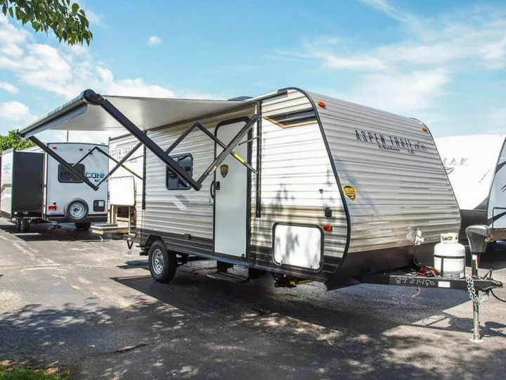 Experience outdoor leisure! This RV rental travel trailer, an Aspen Trail model with its awning extended, awaits adventure.. Dutchmen Aspen Trail LE 1950BH 2020