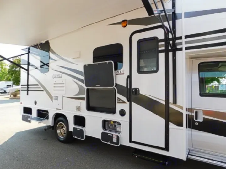 Explore this white RV rental featuring an outdoor entertainment area, extended awning, and side access door.. Entegra Coach Odyssey 2019