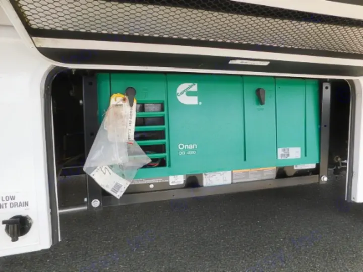 Essential for your RV rental, this image displays a green Cummins Onan QG 4000 generator providing onboard power.. Entegra Coach Odyssey 2019