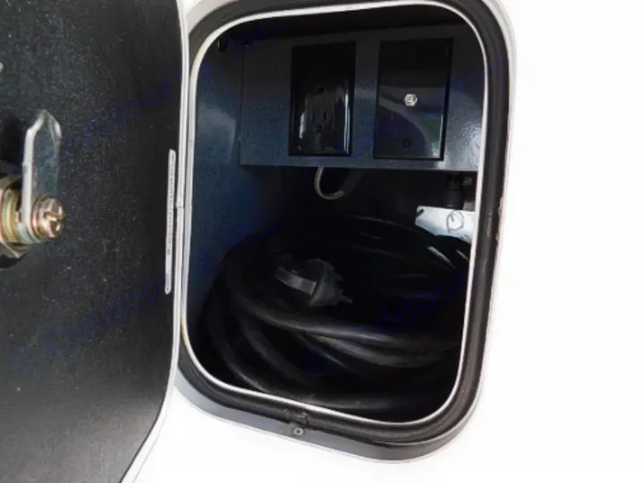 RV rental utility compartment with coiled power cord, electrical outlet, and coaxial hookup for easy connections.. Entegra Coach Odyssey 2019