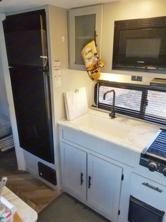 A marble base sink with optional covering for extra counter space. Large refrigerator with various kitchenware available.. Forest River Salem FSX 2021