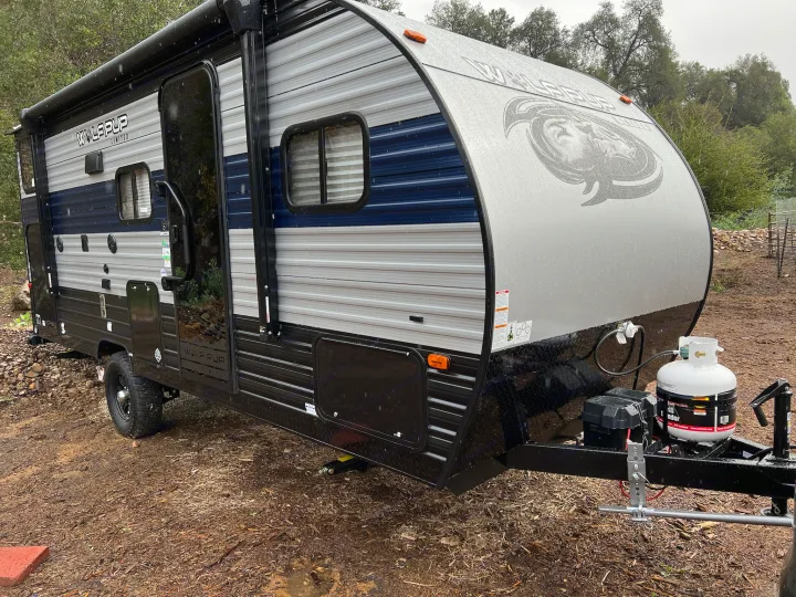 Wolf Pup rv rental, a compact travel trailer, parked outdoors on a damp day. Ready for your next camping adventure.. Forest River Cherokee Wolf Pup 2022