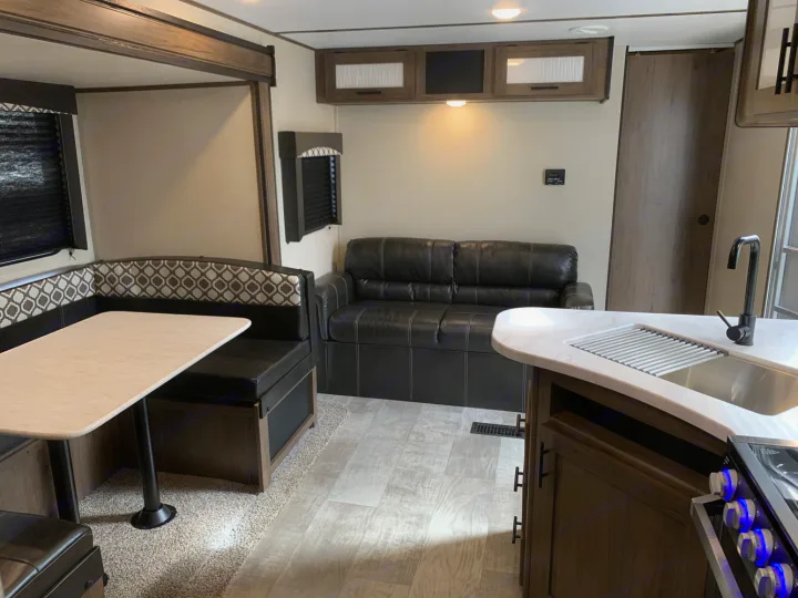 Spacious RV rental interior with dinette, sofa, and a well-equipped kitchenette. Perfect for your next adventure.. Prime Time Avenger 2021