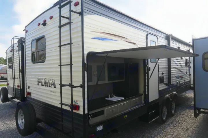 Puma RV rental: travel trailer with rear ladder & unique outdoor kitchen featuring a sink, counter, and storage.. Palomino Puma 2018