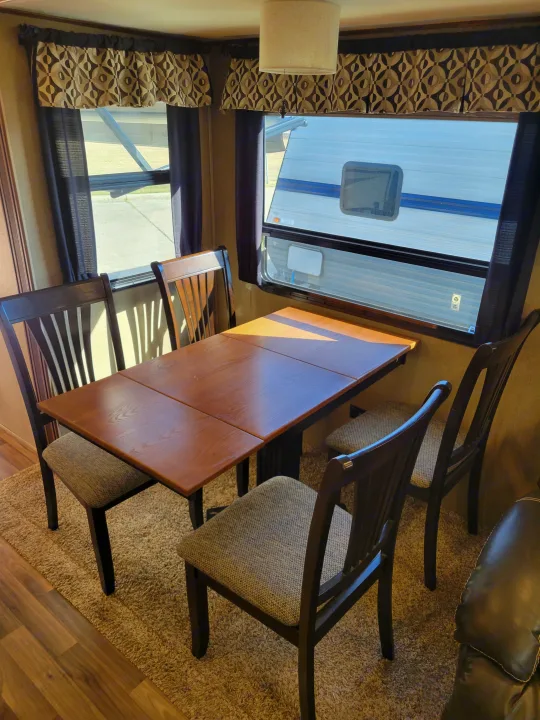 Modern RV rental interior featuring a practical dinette with seating for four and panoramic windows.. Forest River Chaparral 2017