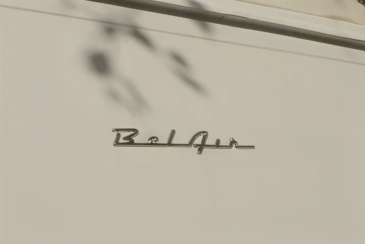 Chrome 'Bel Air' emblem on a light-colored RV rental, showcasing its classic lettering and surface reflections.. Ford E350 Box Van 2003