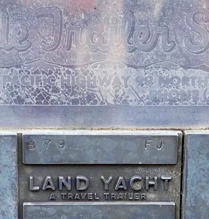 Vintage embossed plaque for "LAND YACHT A TRAVEL TRAILER" (model 379 FJ). Historic rv rental sign from Pacific Hwy 99 N.. Airstream Overlander 1969