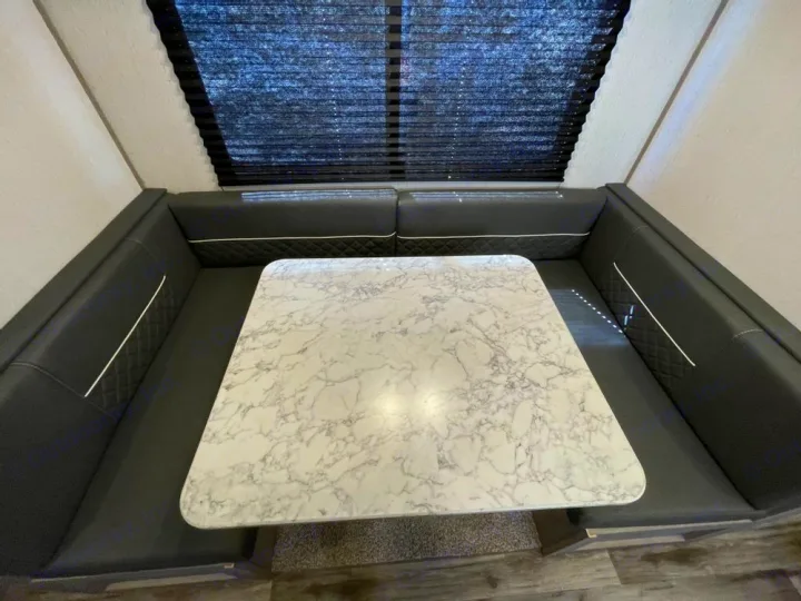 Spacious RV rental dinette with comfortable black booth seating and a white marble-look table, ideal for travel.. Coleman Lantern 300tq 2022