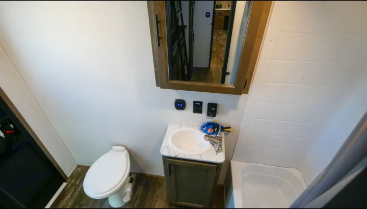 RV rental bathroom features a toilet, sink vanity with Dory toy, mirrored cabinet, and tub/shower combo. Ready for your travels.. Forest River Sabre 2021