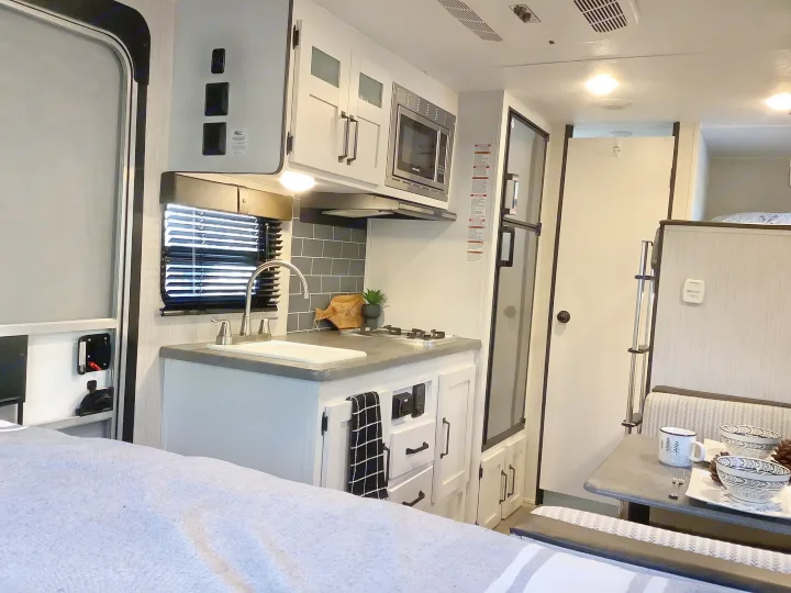Spacious RV rental interior featuring kitchen, dining area, and cozy bed. Perfect for your next camper adventure.. Other Other 2021