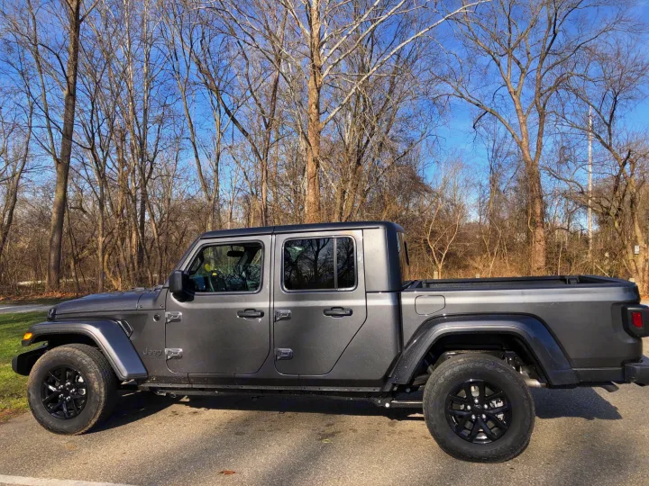 This gray Jeep Gladiator pickup is parked, ready for adventure. Ideal for exploring, consider it for your next trip alongside an RV rental.. Jeep Gladiator 2021
