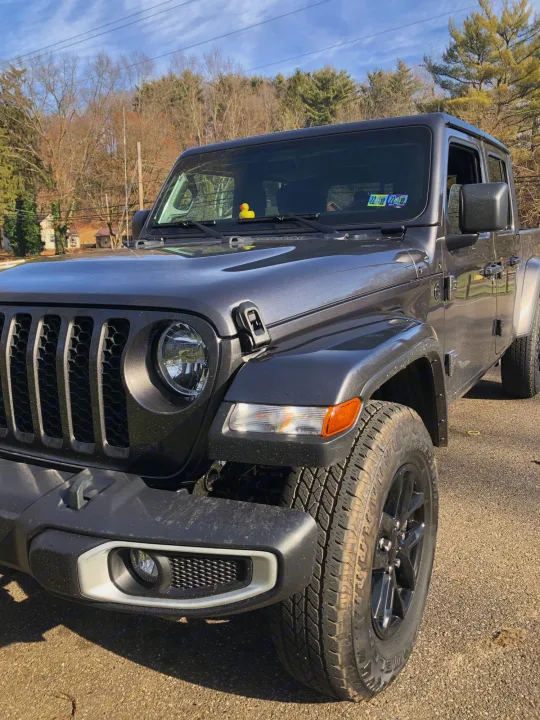 A gray Jeep Gladiator truck, ideal for adventures. Like an rv rental, it offers outdoor freedom. Note the dashboard duck.. Jeep Gladiator 2021