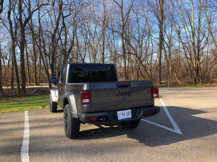 Gray Jeep Gladiator truck, parked in a wooded lot, ready for your next adventure or complementing an RV rental.. Jeep Gladiator 2021