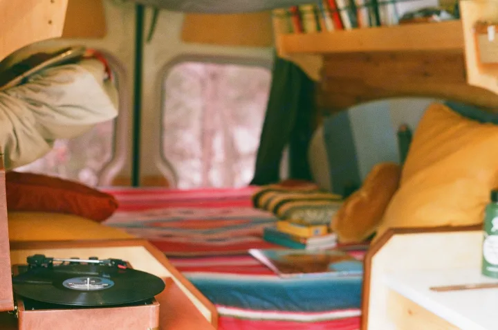 This rv rental offers a cozy interior with a vintage record player, books, and colorful textiles for comfort.. Freightliner Sprinter 2007