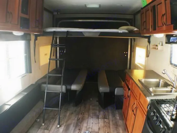Spacious rv rental interior featuring a queen bunk, convertible benches, and full kitchen, perfect for adventurers.. Pacific Coachworks Rage'N 2015